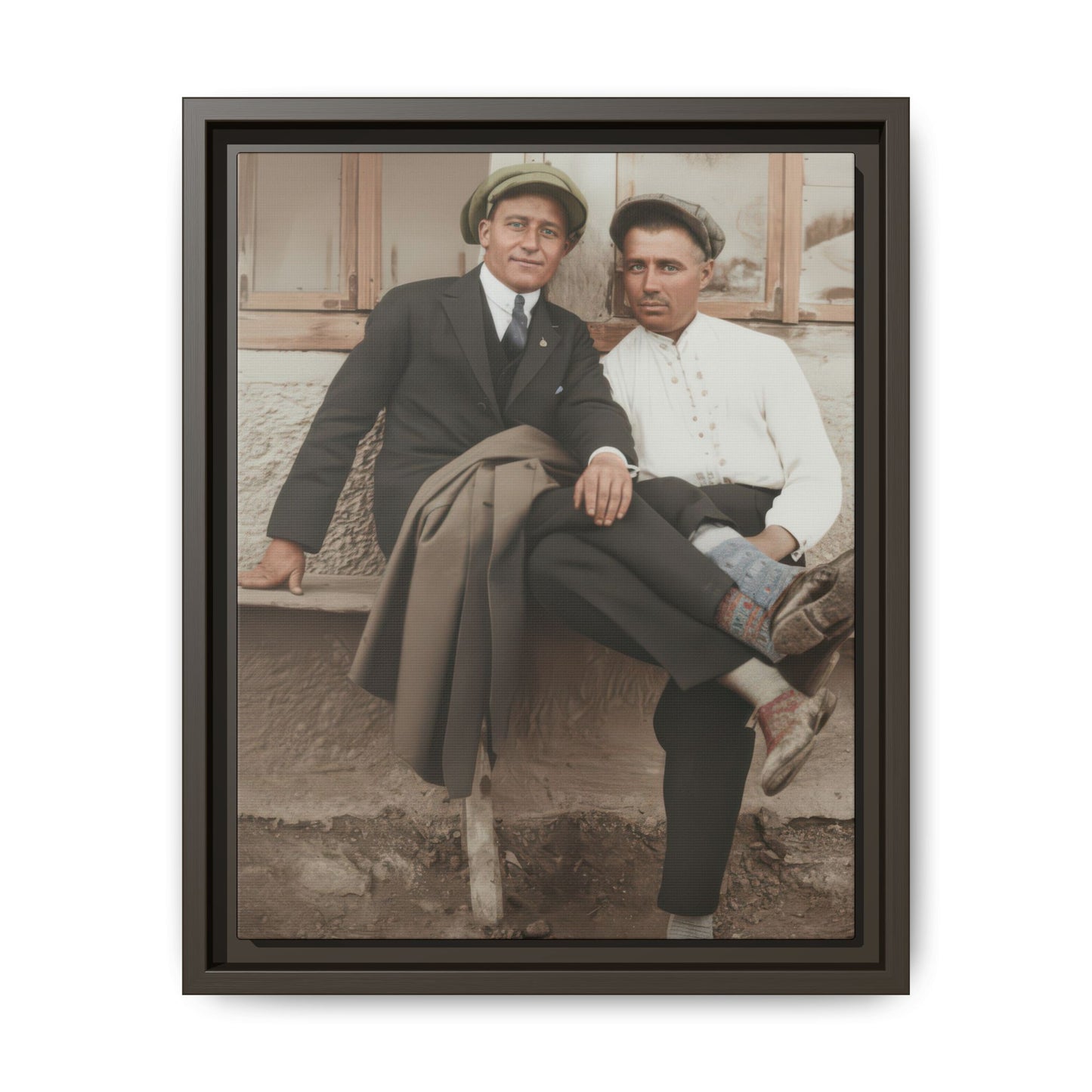 Historical paired portrait showing two men seated closely outside a building, one in a dark suit and one in a light shirt