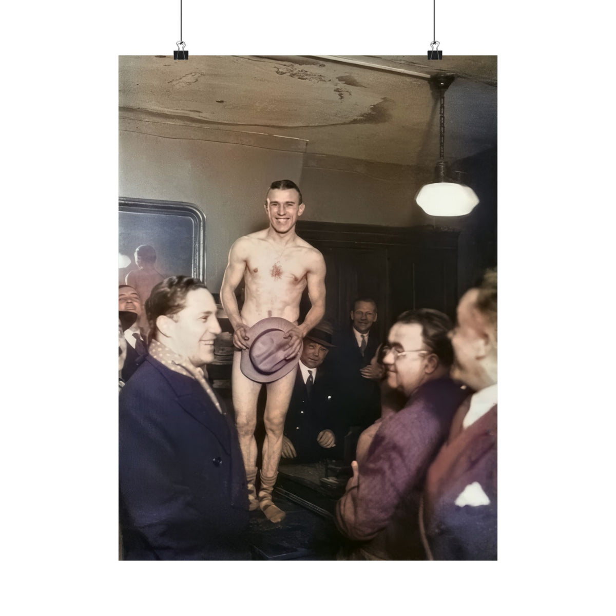 Smiling bare-chested male entertainer holding a brimmed hat before a gathered group of suited men in an interior, circa 1925–1935.