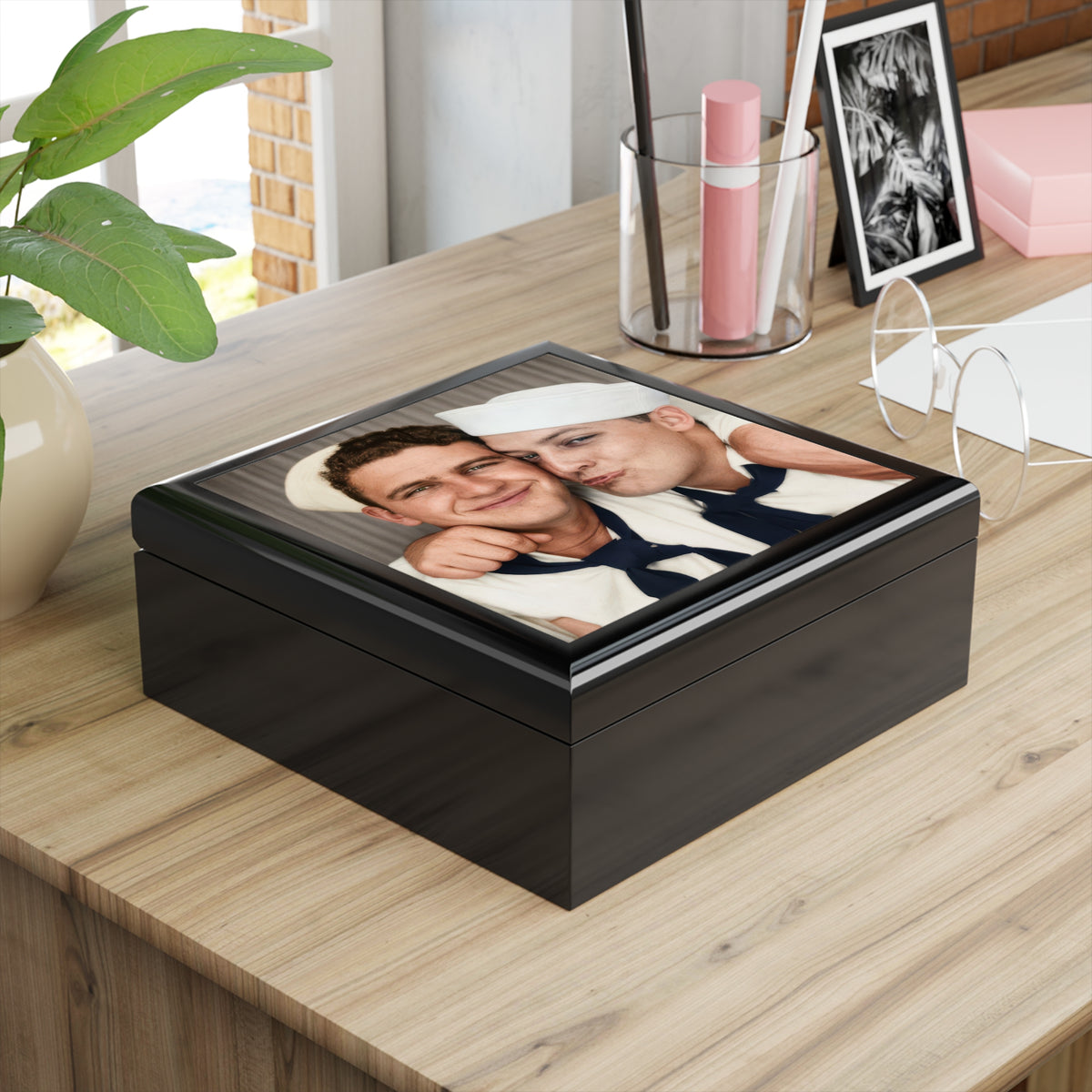 Open wooden keepsake box with felt-lined interior and a ceramic tile lid featuring the two-sailor photobooth image.