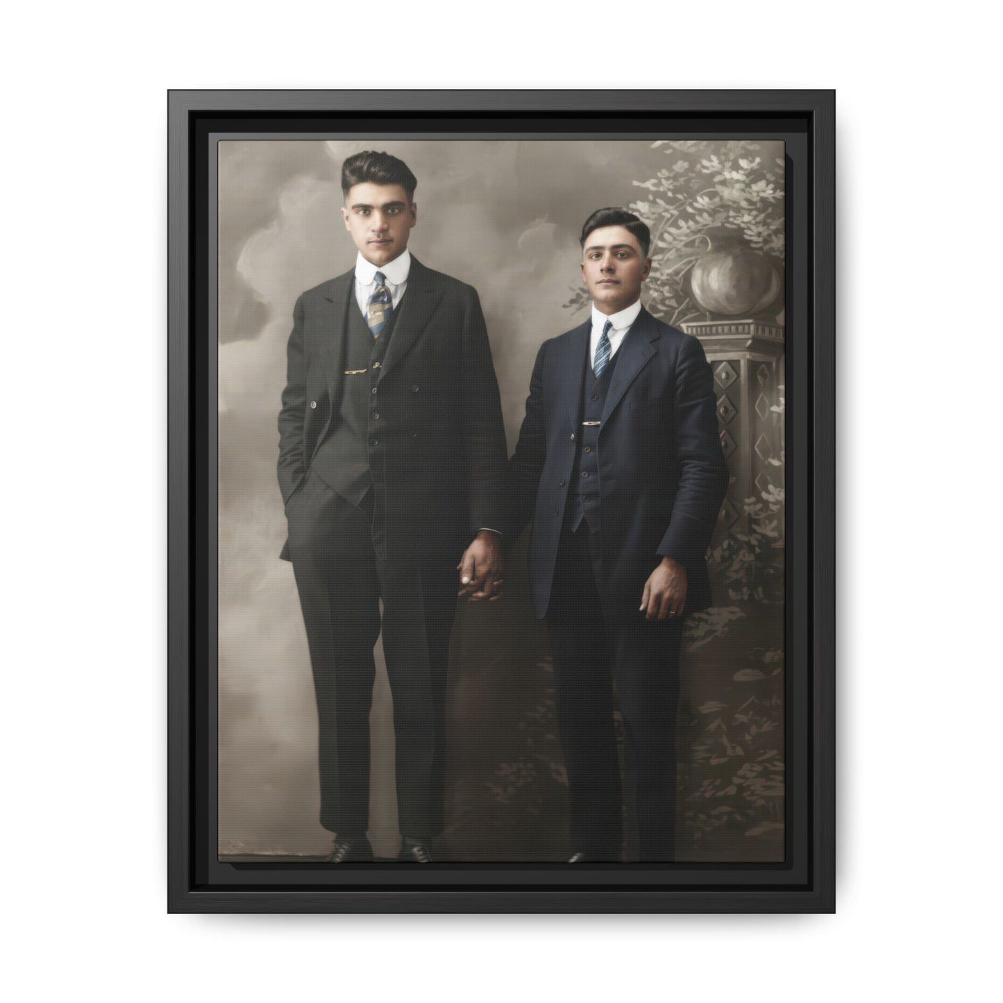 Vintage standing double portrait of two men in dark suits holding hands before a painted studio backdrop