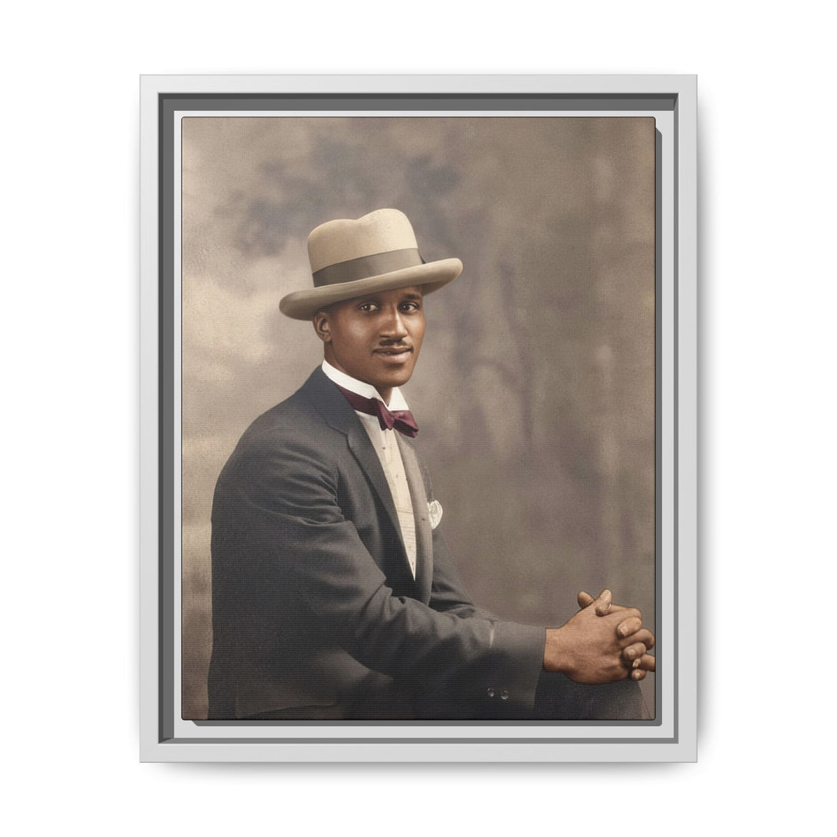 Restored vintage studio portrait of a seated Black man wearing a light felt Homburg hat, charcoal jacket, and burgundy bow tie.