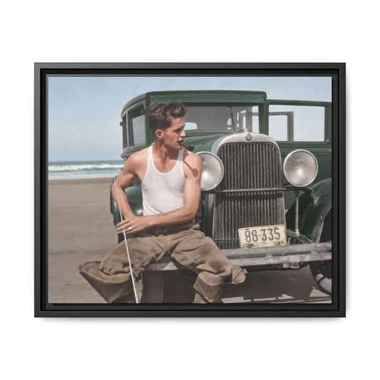 Man looking to the side before a vintage automobile with circular headlamps and an upright grille, with beach surf behind him.