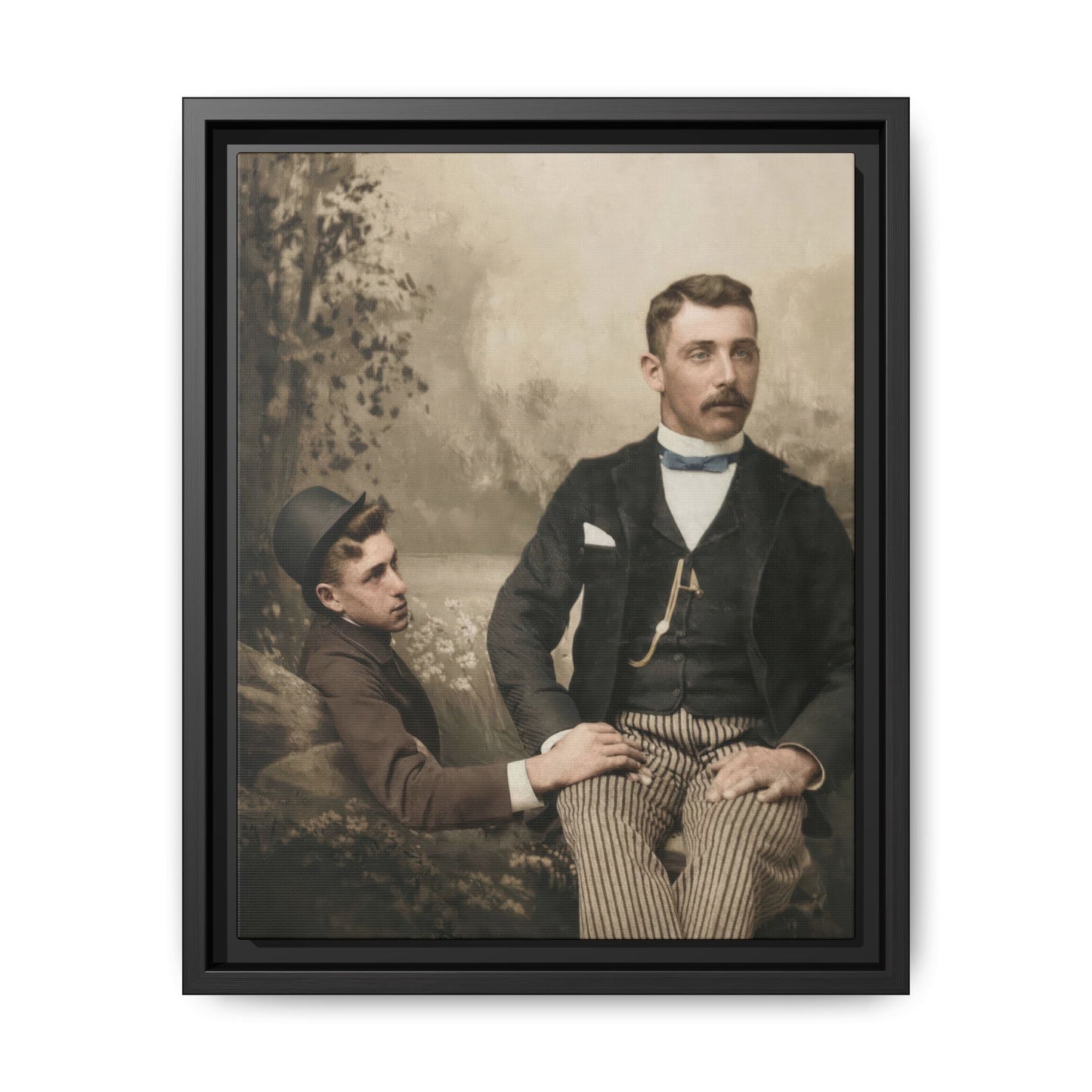 Vintage studio double portrait of two men with one seated in striped trousers and one reclining beside him against a painted backdrop