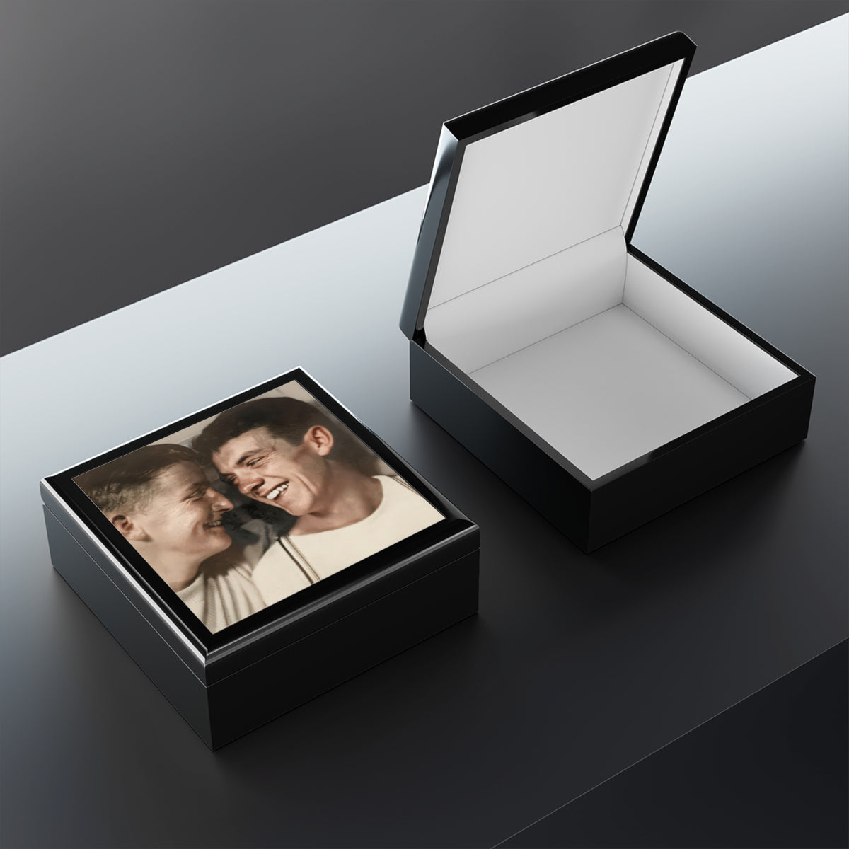 Open wooden keepsake box showing felt lining and a raised lid, with the smiling double portrait visible on the lid exterior.