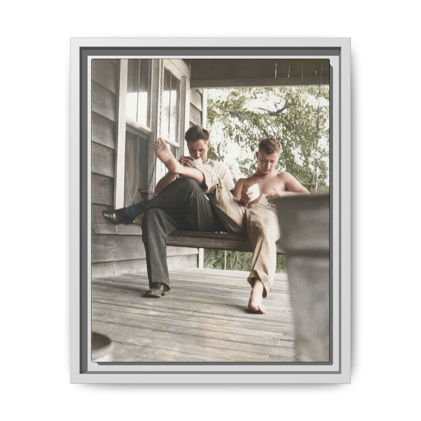 Vintage outdoor portrait of two men seated on porch swing early 1900s