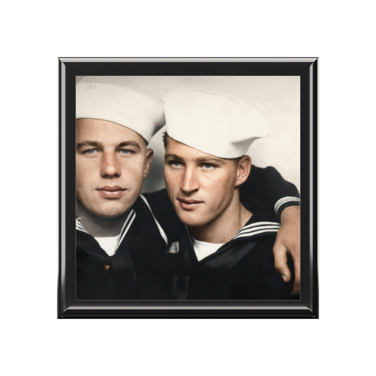 Closed wooden keepsake box viewed at an angle, with a vintage portrait of two sailors in white caps on the ceramic tile lid.