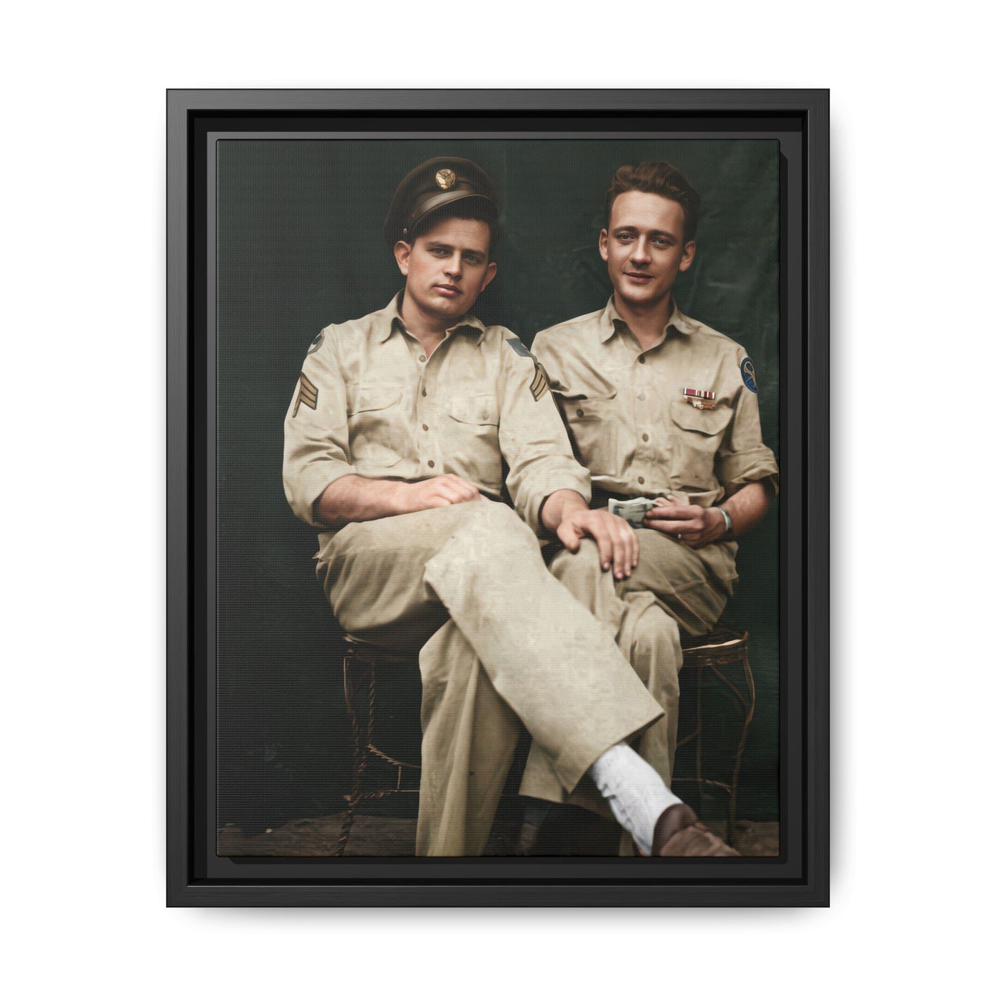Vintage portrait of two seated companions in service uniforms against a dark backdrop