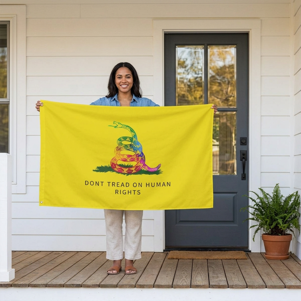 Person holding a 3x5 yellow human rights flag with rainbow snake design on a front porch